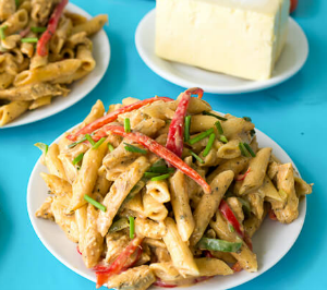 An easy recipe for making the delicious rasta pasta dish of a creamy jerk sauce smothering penne pasta, bell peppers and your choice of meat. Close up of a plate of rasta pasta