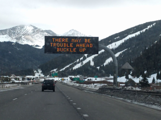 There May Be Trouble Ahead Buckle Up | road sign in Colorado