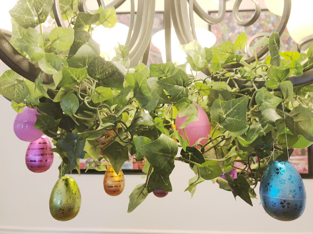 Take your Easter Egg hunt inside with this fun Easter decoration. It's so easy to decorate your dinning room chandelier with beautiful Easter eggs and greenery to make a stunning Easter Egg Chandelier that will bring some extra sparkle and shine to your Easter dinner.