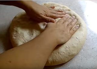 Quitandole el exceso del aire a la masa del pan para poder amasarla durante dos minutos y luego dejarla reposar nuevamente
