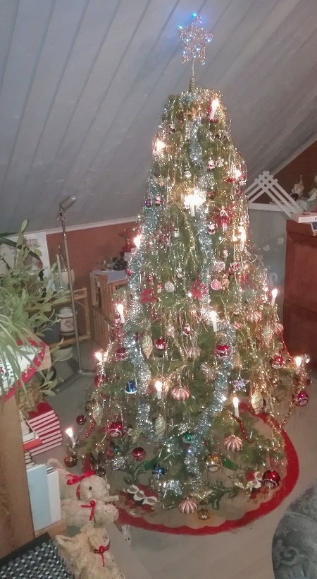 Tekojoulukuusi säihkyvänä täyteen koristeltu kuusipuu