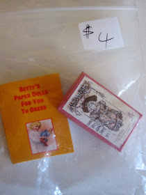 Miniature book of paper dolls and box with image of a Victorian doll on the front, in a bag priced at $4.