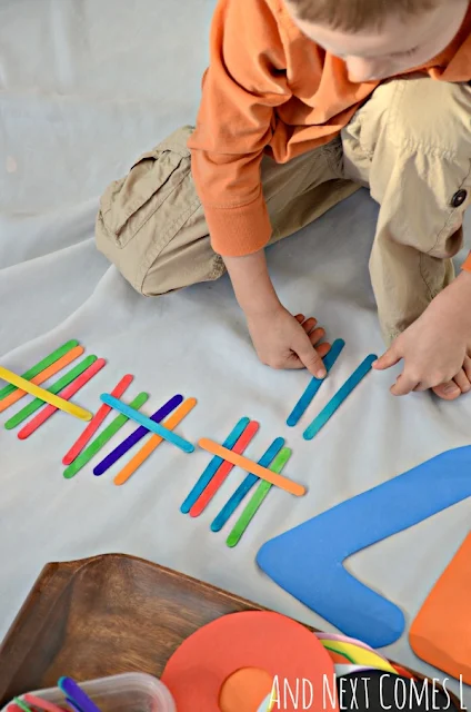 Child counting tally marks with colored craft sticks