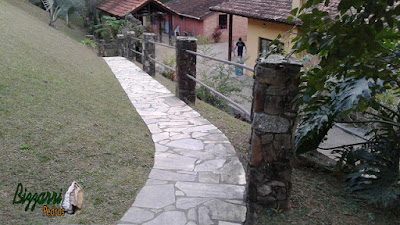 Caminhos com pedras caco de São Tomé com o corrimão de ferro preso nos pilares de pedra em sítio em Atibaia-SP.