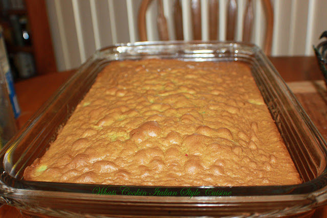 This is a pistachio cake made with a yellow cake mix and pistachio instant pudding baked to a golden brown color in a glass rectangular sheet cake pan