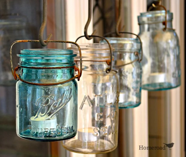 Mason jars hanging in a row with candles