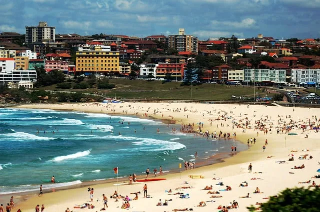Bondi beach filled with beachgoers getting a tan, swimming, and surfing