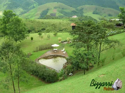 Construção da piscina natural com parede de pedra e no fundo da piscina com piso São Tomé e o piso do passeio com tijolo de demolição.