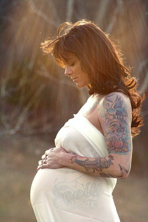 Preciosa imagen de una mujer tatuada que esta embrazada