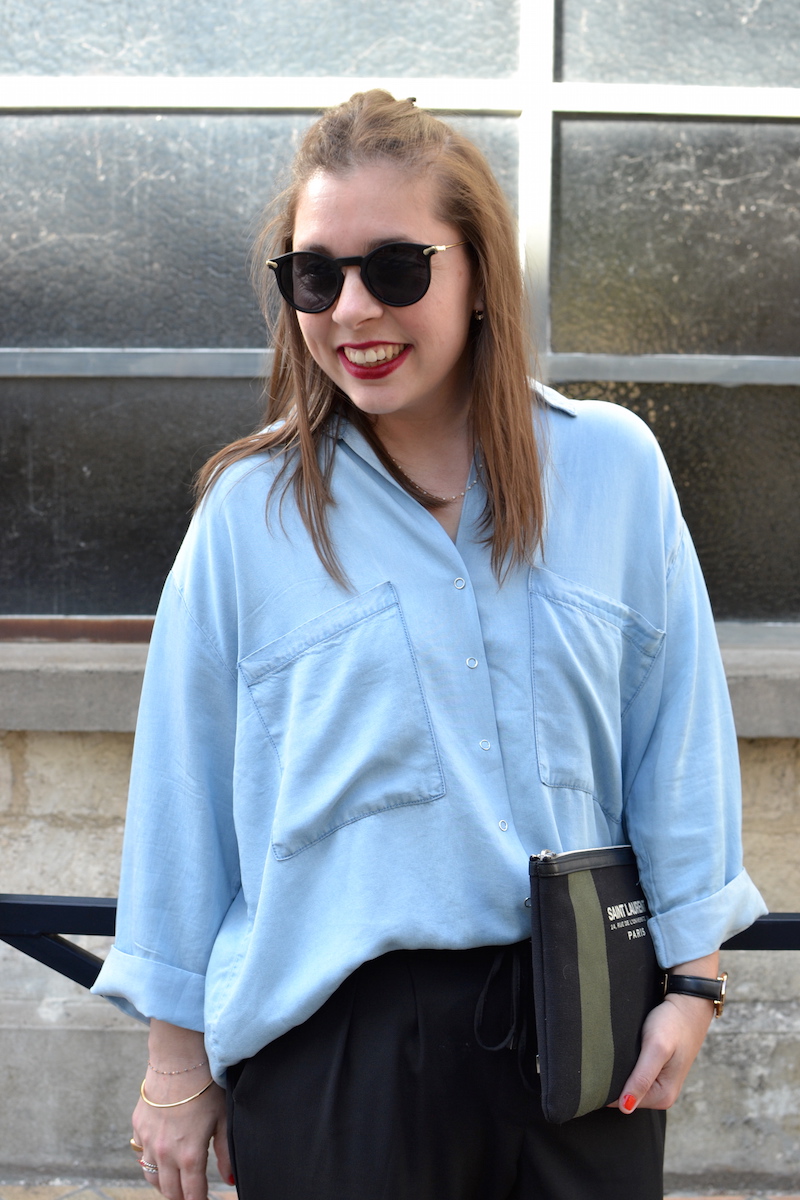 chemise en jean fluide Pimkie, lunette de soleil ronde Asos, pochette Saint Laurent de la Boutique Espaces, pantalon fluide noir zara