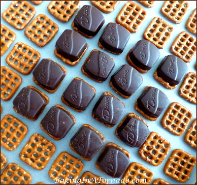 Pretzel Sandwich Snacks: Different flavored chocolates lightly melted between pretzels then partially dipped in vanilla candy melts. A perfect snack for any occasion. | Recipe developed by www.BakingInATornado.com | #recipe #chocolate #snack