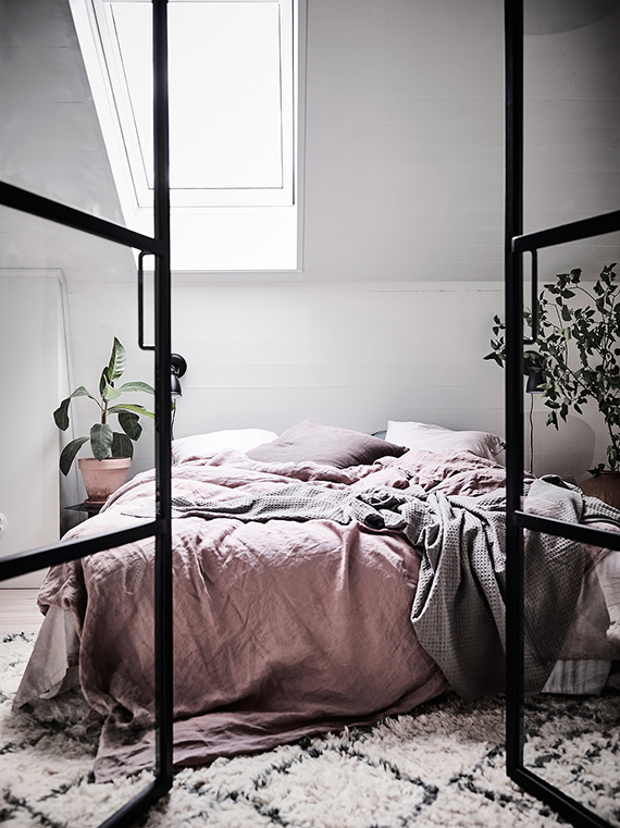Attic bedroom with black metal frame door divider. Photo by Anders Bergstedt