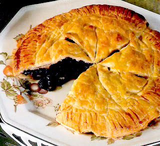 Classic pie of blackcurrant or redcurrants with a slice removed served as a dessert or teatime treat