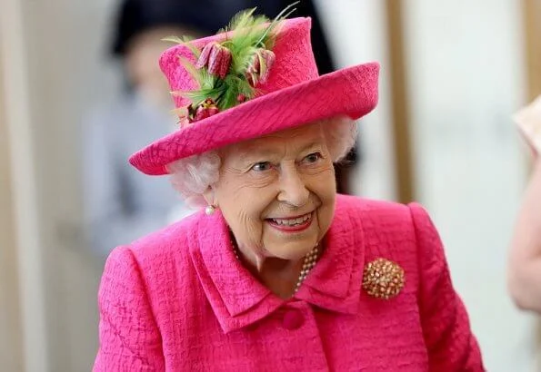 Queen Elizabeth wore a floral satin dress, pink coat and pink hat, pearl necklace, pearl earrings and diamond brooch