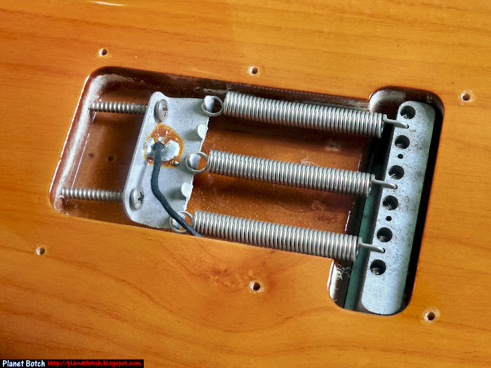 Behind the backplate looking into a vintage Stratocaster vibrato cavity with three springs