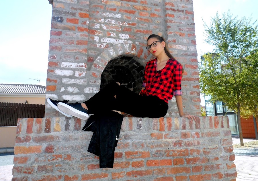 Camisa de cuadros con chaqueta de cuero, jeans rotos y bambas