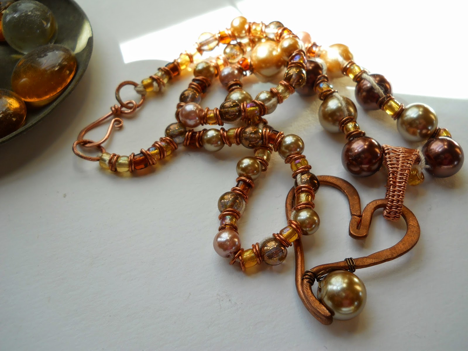 Glass beads and Pearls in warm rich coppery tones with copper accents and copper heart pendant.