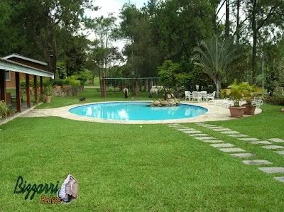 Execução de caminho no jardim com pedra folheta do tipo 40x40 cm com o lado serrado para execução do caminho de pedra em sítio em Bragança Paulista-SP com casa com piscina, churrasqueira e o gramado com grama São Carlos.