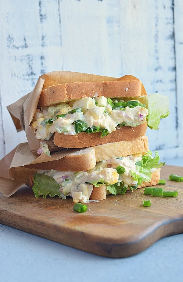 Lots of iceberg lettuce topped with egg salad wrapped in bread 