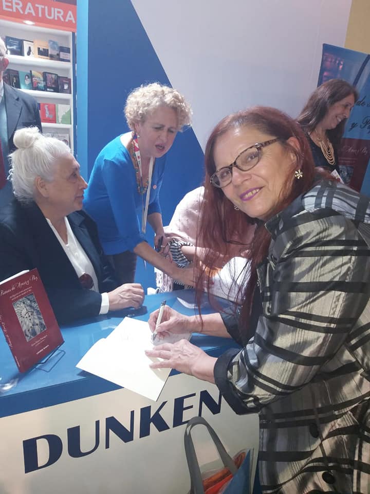 MIRTA PRAINO FIRMANDO EJEMPLARES DE LA ANTOLOGIA POEMAS DE AMOR Y PAZ