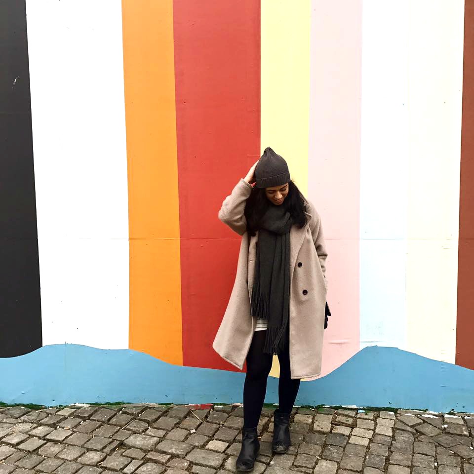 girl in front of colourful wall