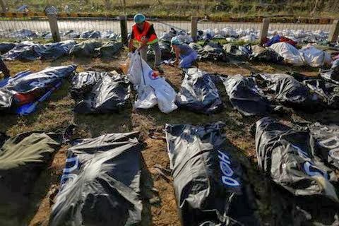 Forensic experts work on a mass grave with more than 700 bodies of victims of Typhoon Haiyan 