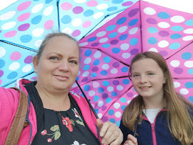 mother and tween daughter under umbrellas