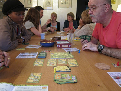 Nottingham - Two of the players consider their options, with the players of Bohnanza in the background