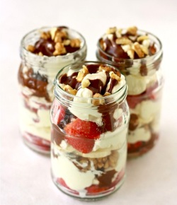 banana split parfait recipe in a jar with homemade chocolate sauce and vanilla whipped cream