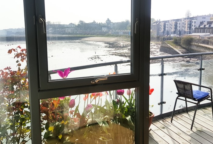 Granton harbour in Edinburgh when the tide is out viewed from a balcony filled with flowers