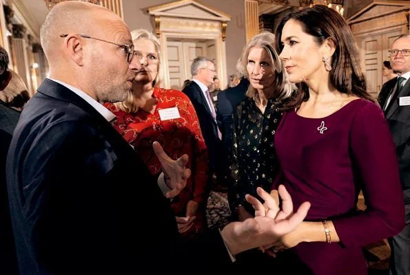 Crown Princess Mary wore Prada purple knee-length dress. The Princess hosted a Christmas reception for Mary Fonden. She wore her Prada purple dress