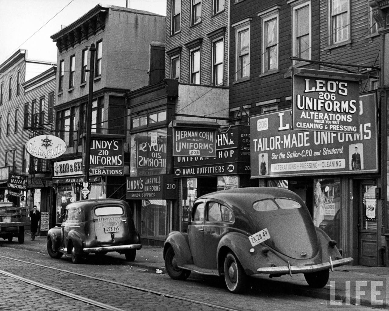 Cars parked in front of four Navy uniform stores on Sand Street ...