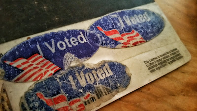 Crusty and gnarled "I voted" stickers on the back of a license. 