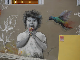 mural of a girl eating flower-shaped ice cream next to a large hummingbird