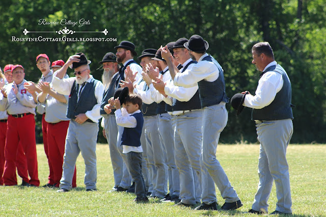 Baseball players standing in a field and cheering at a Vintage baseball game.  The article Vintage Baseball is by rosevinecottagegirls.com
