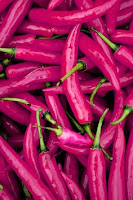 Pile of cayenne peppers photo edited to look magenta in color.