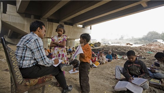 Rajesh Sharma holds free classes for hundreds of slum children under the elevated tracks of the Yamuna Bank Metro station.
