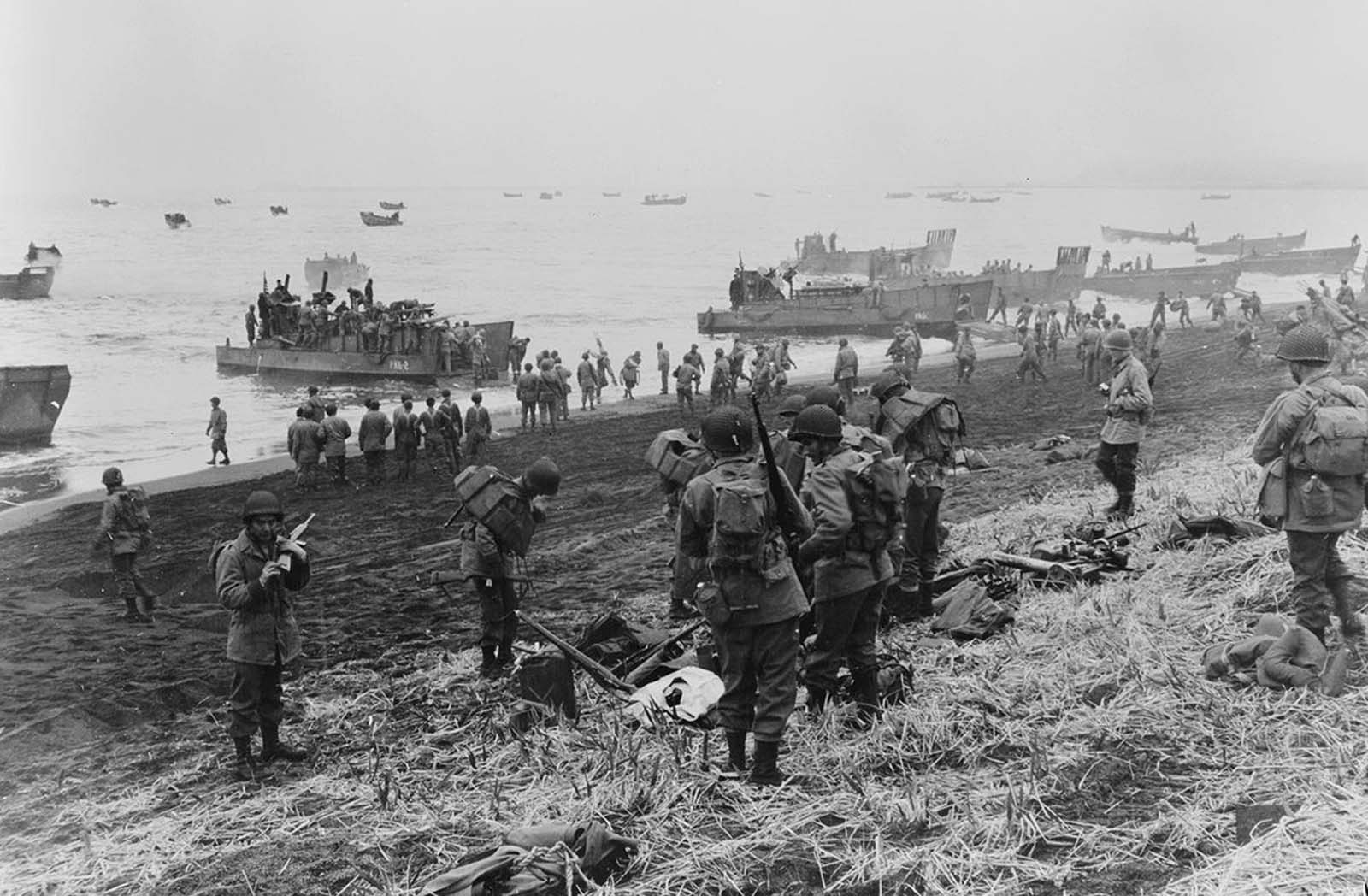 Landing boats pouring soldiers and their equipment onto the beach at Massacre Bay, Attu Island, Alaska. This is the southern landing force on May 11, 1943. The American and Canadian troops took control of Attu within two weeks, after fierce fighting with the Japanese occupying forces. Of the allied troops, 549 were killed and 1,148 wounded -- of the Japanese troops, only 29 men survived. U.S. burial teams counted 2,351 Japanese dead, and presumed hundreds more were unaccounted for.