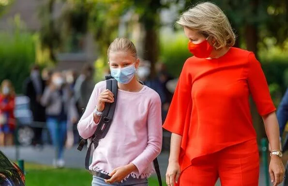 Queen Mathilde wore an Adria asymmetric jumper and Milan trousers, both by Natan, which she had worn before. Princess Eleonore