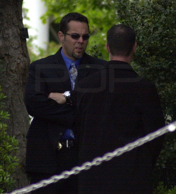U.S. Secret Service engage in conversation outside the White House.