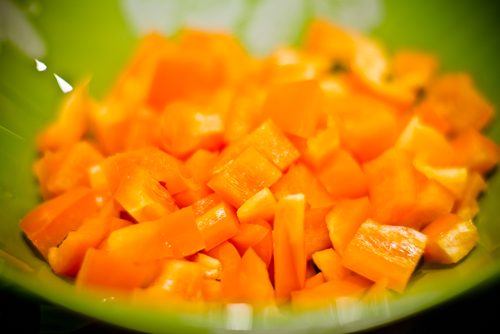 Салат карри. Красный и зелёный сладкий перец нарезать мелкими кубиками. Сладкий оранжевый перец порезанный на тарелке.