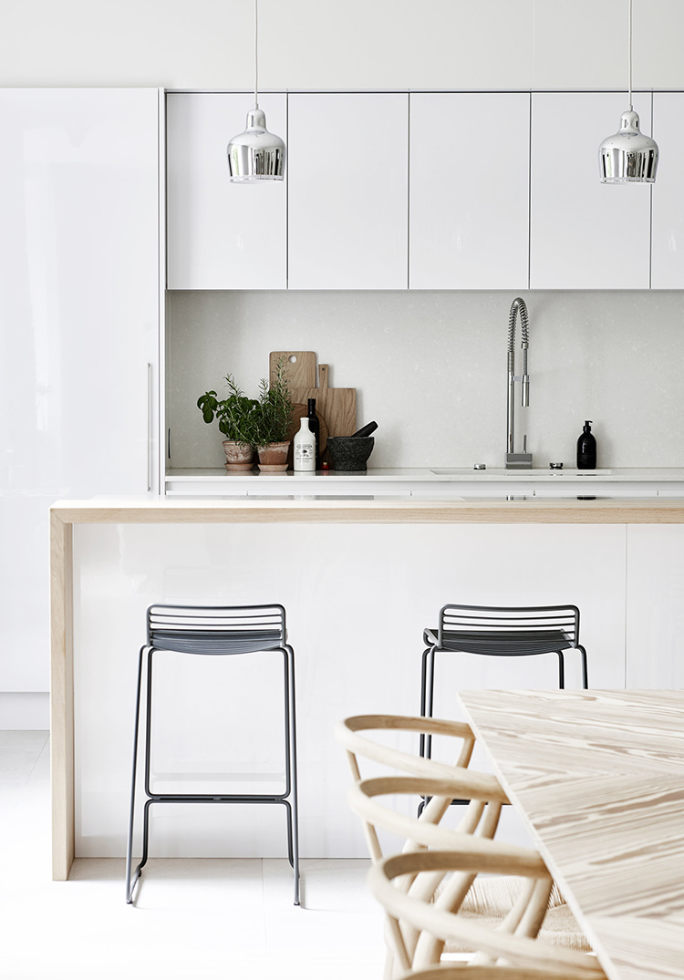 White and wood open kitchen and dining room. Photos by Riikka Kantinkoski for Avotakka