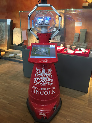 Red anthropomorphic robot with University of Lincoln logo on body