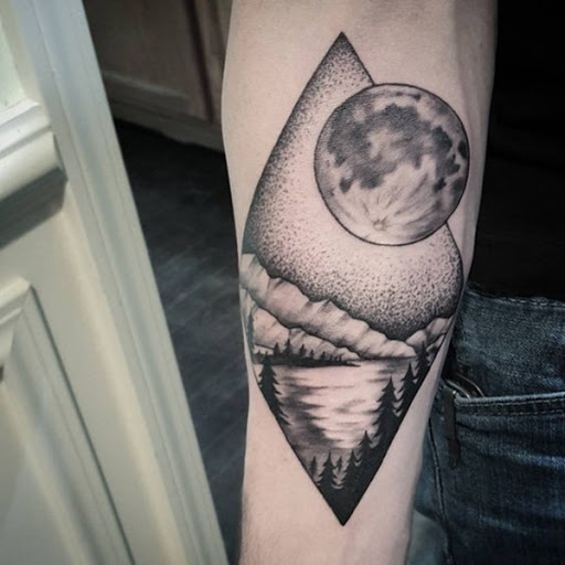 A lua paira sobre uma paisagem, incluindo pinheiros, montanha e um rio em preto e cinza tatuagem.