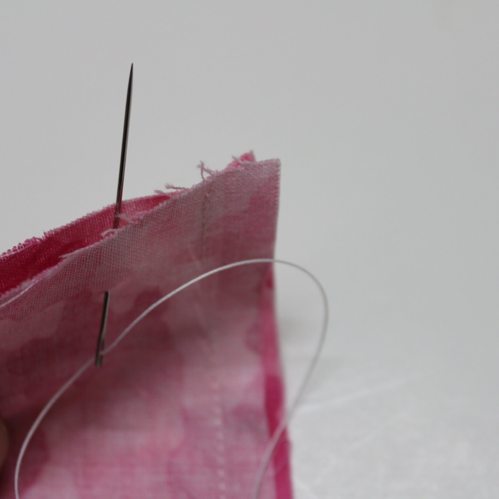 Thread the needle with upholstery thread. tie a knot at one end.