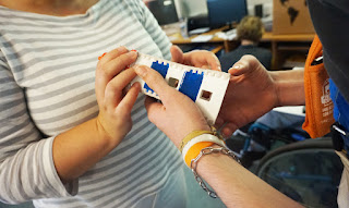 A mão de um aluno a tocar na réplica do farol de Santa Marta 