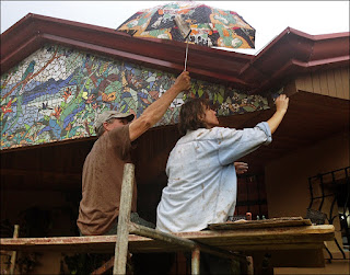 holding umbrella to keep the artist dry