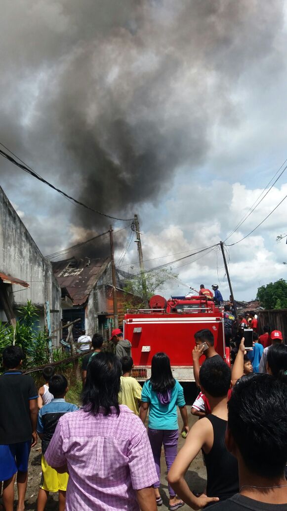 Warga menyaksikan petugas pemadam kebakaran yang sedang memadamkan api. Warga menyaksikan petugas pemadam kebakaran yang sedang memadamkan api.