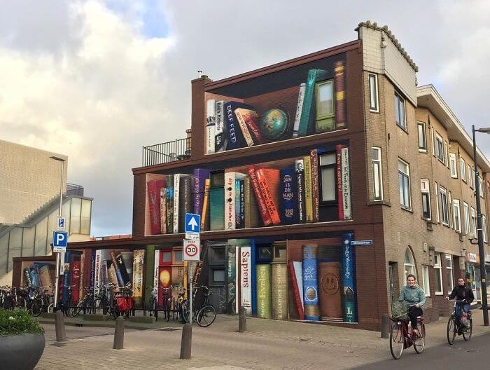 Dutch Artists Paint An Enormous Bookcase On An Apartment Building That Features Residents’ Favorite Books