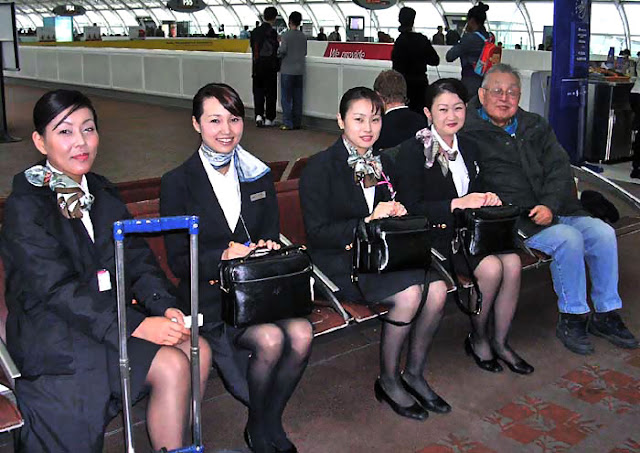 Japan Airlines cabin crew taking picture with a passenger Japan Airlines cabin crew taking picture with a passenger